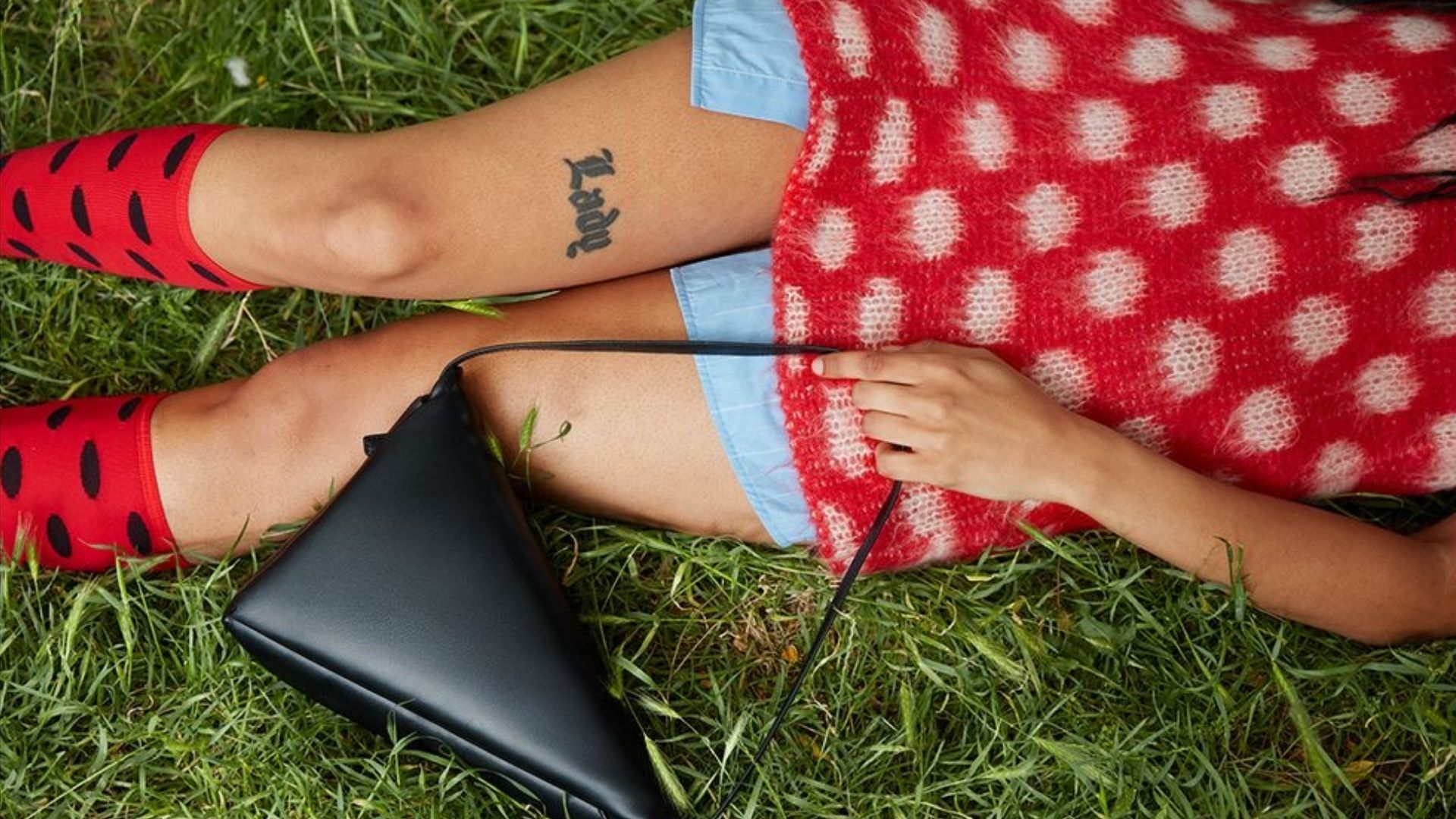 Marni brand imagery, polka dot knitwear and leather bag on grass